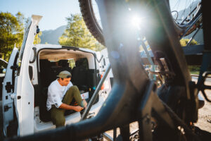 Mountain biker preparing gear inside a van before a ride in the Alps – photo by Andrea Passerini